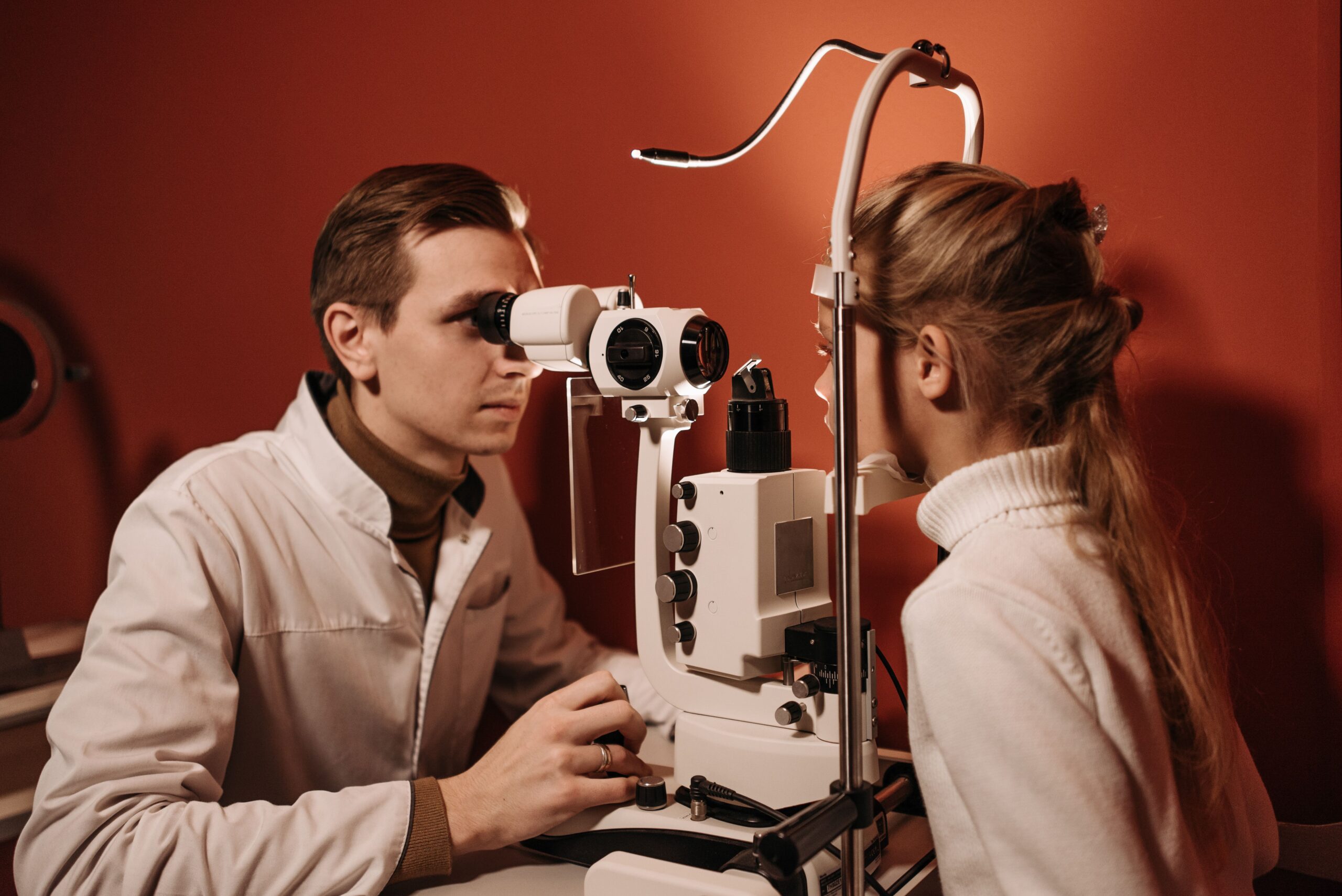 Ophthalmologist conducting an eye exam with advanced diagnostic tools on a young girl.